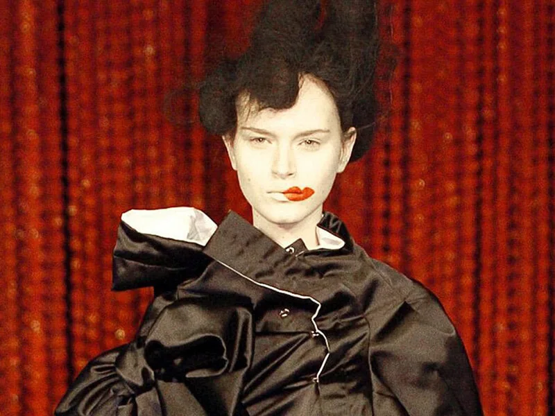赤い唇の化粧をした、黒い服のモデル